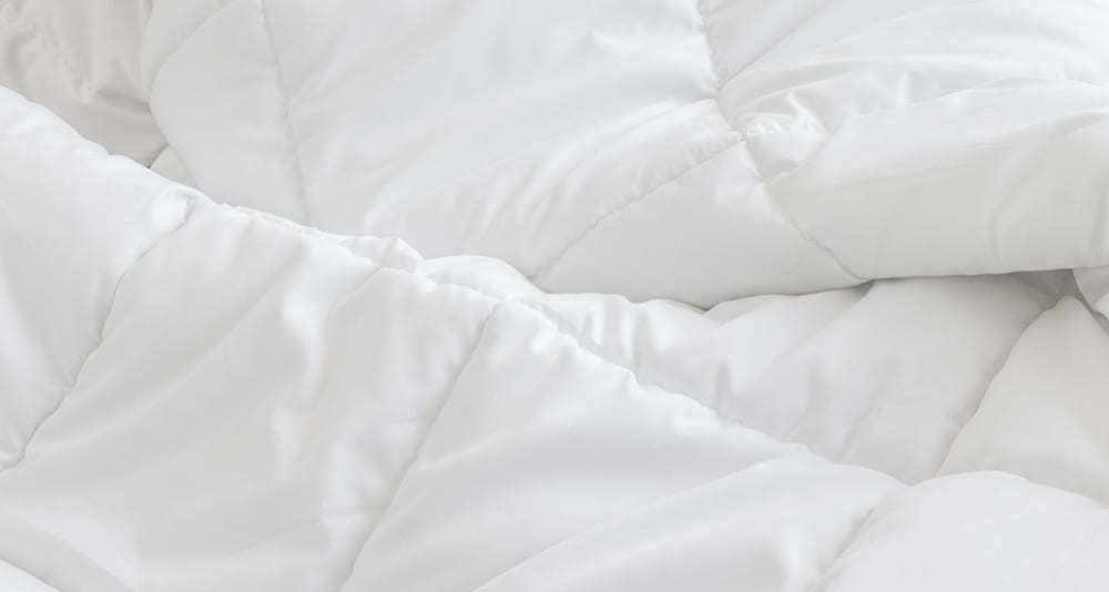 A white comforter on a bed