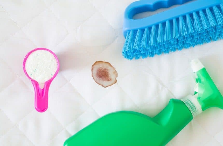 Green spray bottle, pink cup or scoop of washing powder and brush to remove blood stains from sheets
